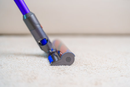 Woman cleaning Carpet with cordless Vacuum cleaner. Housewife using wireless Hoover for big cleaning home. Housework, Housecleaning, Housekeeping, Removes dust, Domestic hygiene and daily routineの写真素材