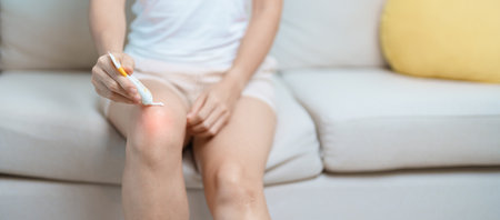 Arthritis and Muscle Pain Relief Cream concept. woman having knee ache and muscle pain due to Runners Knee or Patellofemoral Pain Syndrome, osteoarthritis, rheumatism and Patellar Tendinitisの写真素材
