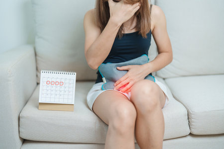 Menstruation period cycle of monthly and Stomachache concepts. woman having abdomen pain with hot water bottle and calendar, illness female suffer from premenstrual ache and body Health problemの写真素材