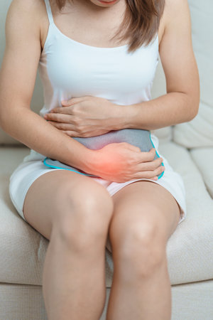 Menstruation period cycle of monthly and Stomachache concepts. woman having abdomen pain and menstrual ache with hot water bottle, illness female suffer from premenstrual ache and body Health problemの写真素材