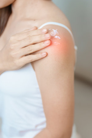 Arthritis and Muscle Pain Relief Cream concept. Woman having Shoulder and Arm pain at home. Muscle...