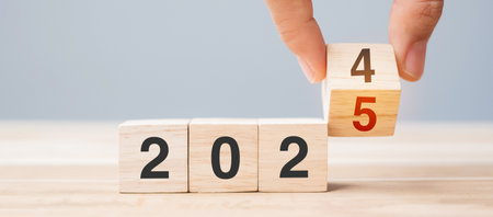 hand flip cube block 2024 to 2025 text on table. Resolution, review, strategy, end year, goal, business and New Year holiday conceptsの写真素材