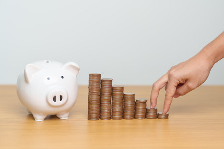 Money Saving for Future Plan, Retirement fund, Pension, Investment, Wealth, Salary and Financial concepts. hand step up coin with piggy bank on table, Money Counting and stack arrangement for Growthの写真素材