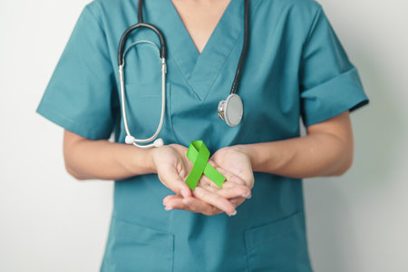 Doctor with green Ribbon for world Lymphoma Awareness September month, world Mental Health Day, Liver, Gallbladders, bile duct, cervical, kidney Cancer. Healthcare and world cancer day conceptの写真素材