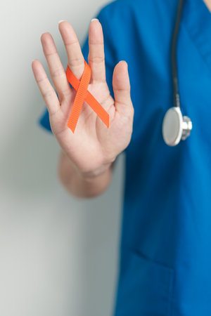 Doctor with Orange Ribbon for Leukemia, Kidney cancer day, world Multiple Sclerosis, CRPS, Self Injury Awareness month. Healthcare and word cancer day conceptの写真素材