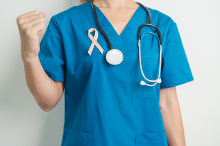 Doctor holding Peach Ribbon for September Uterine Cancer Awareness month. Uterus and Ovaries, Endometriosis, Hysterectomy, Uterine fibroids, Reproductive, Healthcare and World cancer day conceptの写真素材