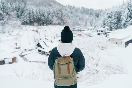 Woman tourist Visiting Ginzan Onsen in Yamagata, happy Traveler sightseeing Japanese Onsen village with Snow in winter season. landmark and popular for attraction in Japan. Travel and Vacation conceptの写真素材