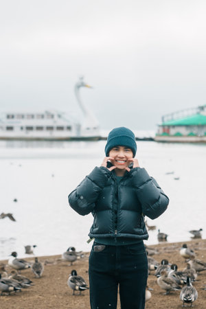 Woman tourist travel Lake Inawashiro in winter, Traveler sightseeing Ducks, Swan and bird in Fukushima Prefecture, Tohoku Region, Japan. Landmark travel and adventure vacation conceptの写真素材