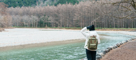 Woman tourist travel Kamikochi National Park, happy Traveler sightseeing Azusa river with mountain, Nagano Prefecture, Japan. Landmark for tourists attraction. Japan Travel, Destination and Vacationの写真素材