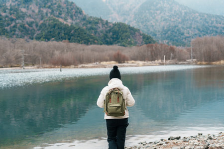 Woman tourist travel Kamikochi National Park, happy Traveler sightseeing Taisho pond with mountain, Nagano Prefecture, Japan. Landmark for tourists attraction. Japan Travel, Destination and Vacationの写真素材
