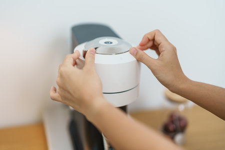 hand making Espresso Coffee by Coffee Maker Machine on wood table bar. Daily beverage drink at Home, Apartment and Office conceptの写真素材