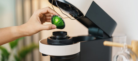 hand making Espresso Coffee by Coffee Maker Machine with Capsule of roasted coffee bean on wood table bar. Daily beverage drink at Home, Apartment and Office conceptの写真素材