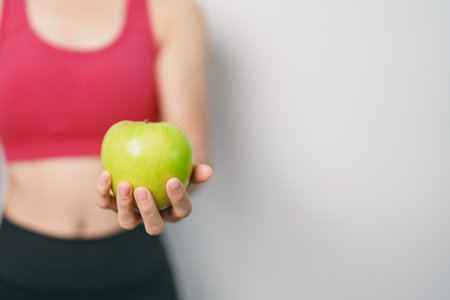 woman hand hold green Apple, happy female fitness choose fruit is Healthy food. Dieting control, Weight loss, Obesity, eating lifestyle and nutrition conceptsの写真素材
