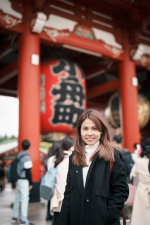 Tourist woman visit Sensoji Temple or Asakusa Kannon Temple is a Buddhist temple located in Asakusa, Tokyo Japan. Japanese sentence on red lantern means Thunder gate.の写真素材