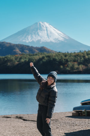 Woman tourist enjoy with Fuji Mountain at Lake Saiko, happy Traveler sightseeing Mount Fuji and road trip Fuji Five Lakes. Landmark for tourists attraction. Japan Travel, Destination and Vacationの写真素材