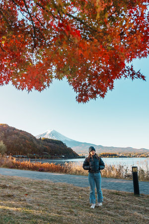 Woman tourist with Fuji Mountain at Lake Kawaguchi in Autumn season, happy Traveler travel Mount Fuji, Yamanashi, Japan. Landmark for tourists attraction. Japan Travel, Destination and Vacationの写真素材
