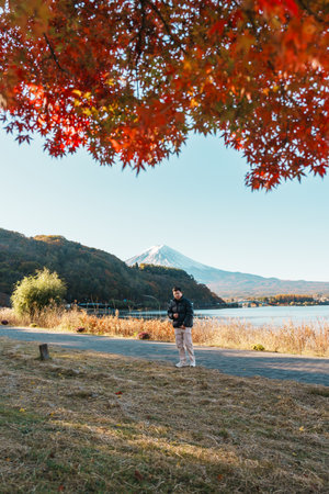 man tourist with Fuji Mountain at Lake Kawaguchi in Autumn season, happy Traveler travel Mount Fuji, Yamanashi, Japan. Landmark for tourists attraction. Japan Travel, Destination and Vacationの写真素材