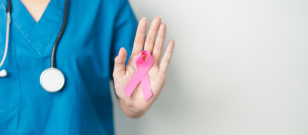 Pink October Breast Cancer Awareness month, woman doctor with pink Ribbon in hospital for support people life and illness. National cancer survivors month, Mother and World cancer day conceptの写真素材