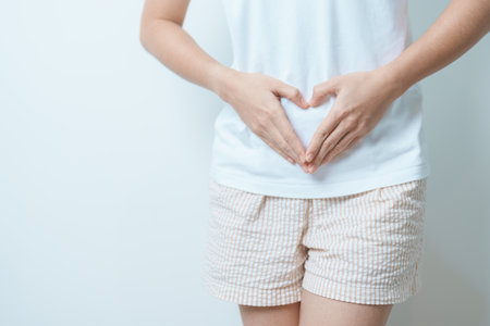 Woman hand heart shape over abdomen. Ovarian and Cervical cancer, Endometriosis, Hysterectomy, Uterine fibroids, Reproductive, menstruation, Stomach, Pregnancy and Sexual Transmitted disease conceptの写真素材