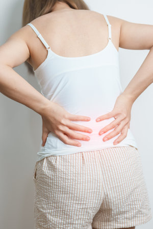 woman having back body ache during at home. adult female with muscle pain due to Piriformis Syndrome, Low Back Pain and Spinal Compression. Office syndrome and medical conceptの写真素材