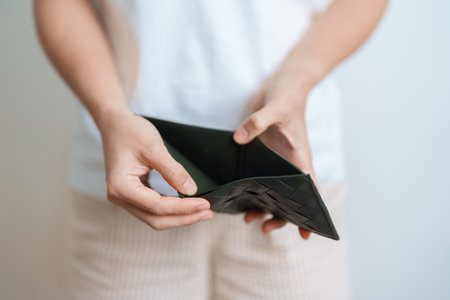 Woman hand holding and open empty wallet with not have banknote money. Crisis, loan, bankrupt and debt financial concept.の写真素材