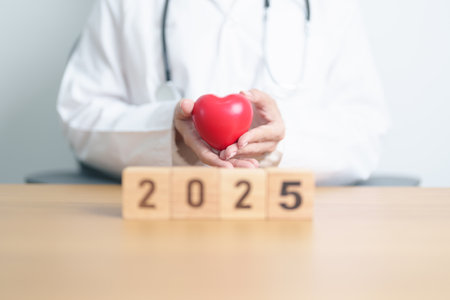 Happy New Year 2025 with doctor holding red heart shape on table. health care, Insurance, donation, Wellness and medical conceptsの写真素材