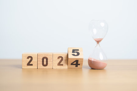 2024 end year to Happy New Year 2025 with hourglass on table. Resolution, time, plan, goal, motivation, reboot, countdown and New Year holiday conceptsの写真素材