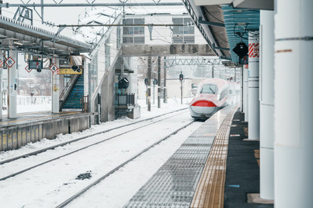Akita Shinkansen in winter, JR E6 Shinaknsen Bullet train arriving at Tazawako Station platform for...