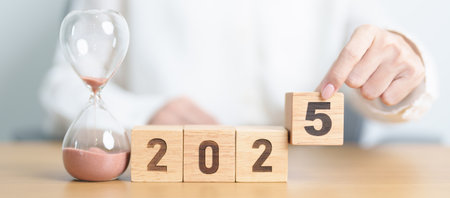 Happy New Year 2025 with hourglass on table. Resolution, time, plan, goal, motivation, reboot,...
