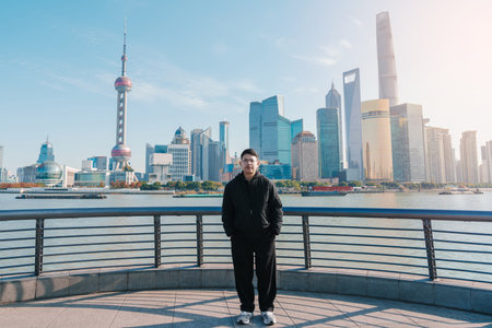 man traveler visiting in Shanghai, China. male Tourist sightseeing Shanghai view of Lujiazui in The Bund of Shanghai. landmark and popular for tourism attractions. Vacation conceptの写真素材
