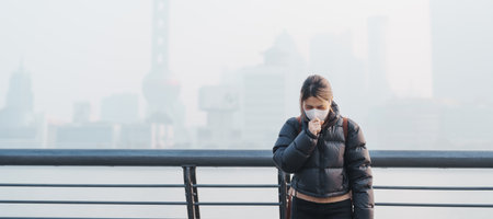 young Asian woman wearing respiratory mask protect and filter pm or particulate matter against bad Air Pollution in Shanghai City, China. Air Quality Index, AQI, Unhealthy, healthcare conceptの写真素材