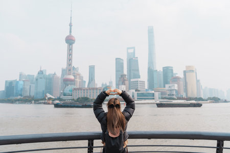 woman traveler visiting in Shanghai, China. Female Tourist with backpack sightseeing Shanghai view...
