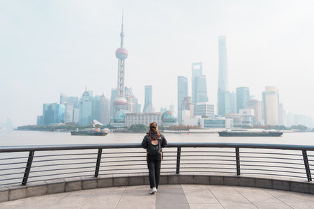 woman traveler visiting in Shanghai, China. Female Tourist with backpack sightseeing Shanghai view...