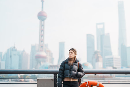 woman traveler visiting in Shanghai, China. Happy Female Tourist sightseeing Shanghai view of Lujiazui in The Bund of Shanghai. landmark and popular for tourism attractions. Vacation conceptの写真素材