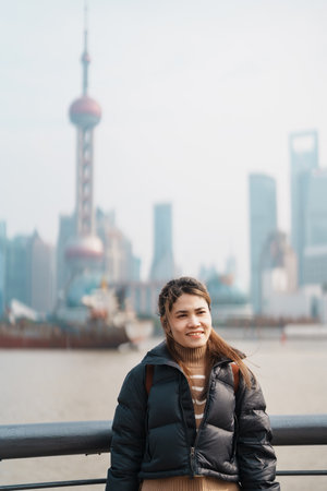 woman traveler visiting in Shanghai, China. Happy Female Tourist sightseeing Shanghai view of Lujiazui in The Bund of Shanghai. landmark and popular for tourism attractions. Vacation conceptの写真素材