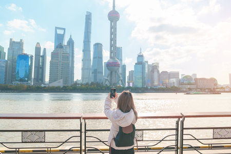 woman traveler visiting in Shanghai, China. Female Tourist with backpack sightseeing Shanghai view...
