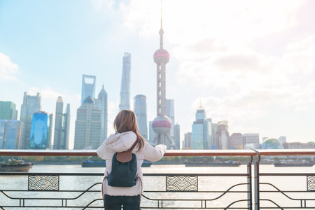 woman traveler visiting in Shanghai, China. Female Tourist with backpack sightseeing Shanghai view of Lujiazui in The north Bund of Shanghai. landmark and popular for tourism attractionsの写真素材