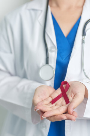 Doctor with Burgundy Red Ribbon for March multiple myeloma Cancer and December World Aids Day...