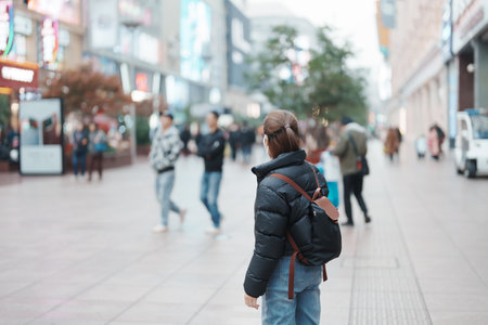 woman traveler visiting in Shanghai, China. Happy Female Tourist sightseeing in Nanjing road,...