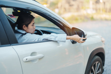Business woman driver adjusting side view mirror a car. Journey, trip and safety Transportation...
