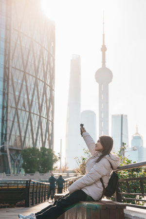 woman traveler visiting in Shanghai, China. Female Tourist with backpack sightseeing Shanghai view...