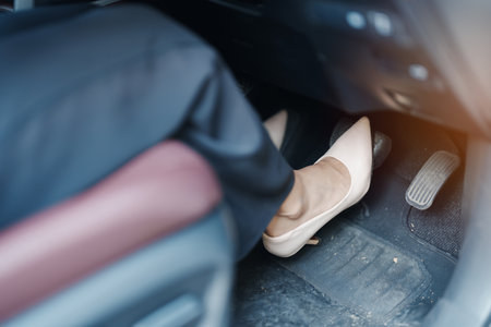 Female driver in high heels, business woman driving car and pushing car break and accelerator pedal. Safety conceptの写真素材