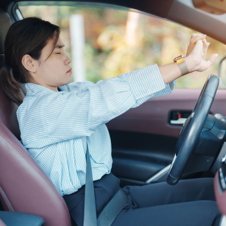 woman feeling sleepy and yawn during drive car long time. Asian girl tired and fatigue having headache after driving car in traffic jam. Sleep, stretching and safety conceptの写真素材