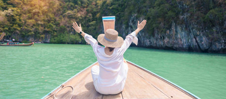 Happy Woman tourist in private longtail boat trip to koh Hong lagoon island at Krabi, Thailand. landmark, tropical destination, southeast Asia Travel, summer vacation, wanderlust and holiday conceptの写真素材