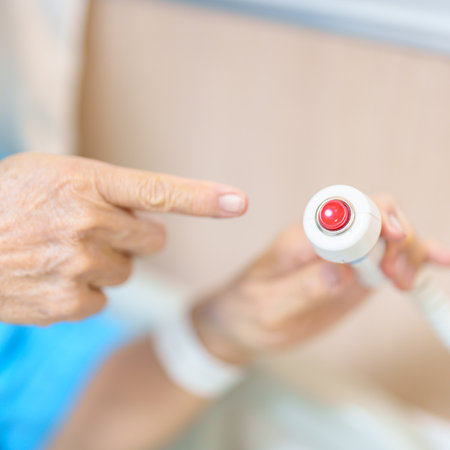 Elderly woman Patient hand holding and pressing emergency button in hospital room, calling nurse in...