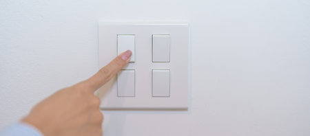 Female finger pushing for turn on light switch on white wall at home room. Woman hand turn off lighting Switch. Energy Saving, energy power control, electrical, eco environment, and lifestyle conceptの写真素材