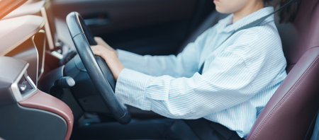 Business woman driver honking a car during driving on traffic road, hand controlling steering wheel in vehicle. Journey, trip and safety Transportation conceptsの写真素材