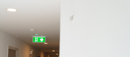 Cracked concrete wall broken wall after Earthquake effect. Damage building with Emergency Exit door sign for emergency. Stairwell for escape in building or apartmentの写真素材