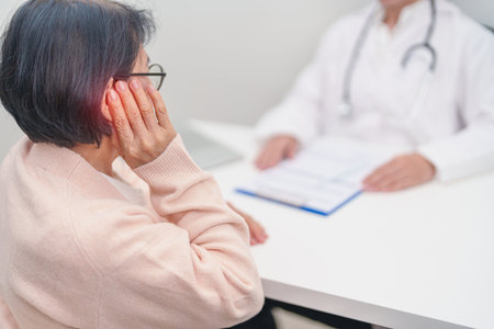 Elderly woman Patient having Earache and consulting Doctor to Ear disease. Senior Health Medical Diagnosis. Atresia, Otitis Media, Pertorated Eardrum, Meniere syndrome, otolaryngologist, Hearing Lossの写真素材
