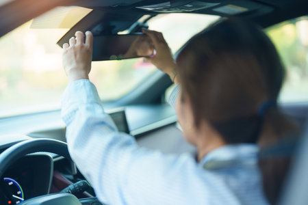 Business woman driver adjusting rear view mirror a car. Journey, trip and safety Transportation conceptsの写真素材